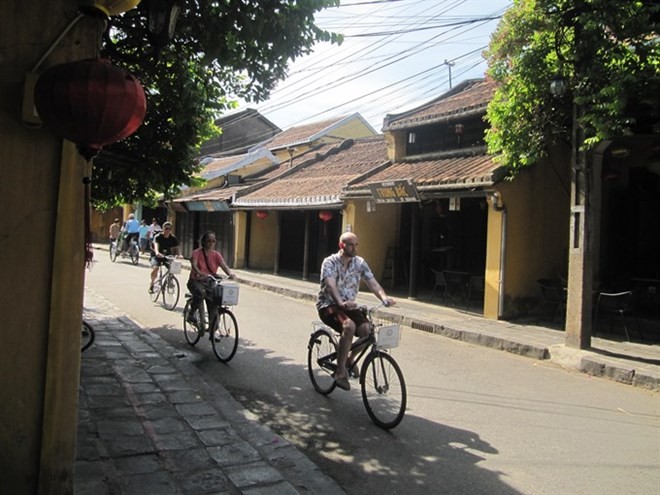 Tourists pedal in an old street of Hoi An (Photo: VNA)