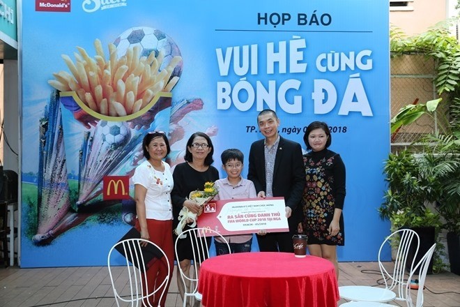 The organising board awards the ticket to Nguyễn Lê Thanh Sơn (middle) (Photo cand.com.vn)