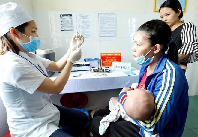 A medical worker prepares to administer vaccine to a baby in the Central Highlands province of Dak Lak (Photo: VNA)