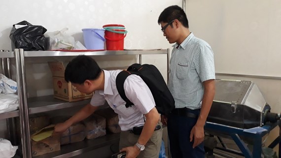 Inspectors check food material at a business (Photo: SGGP)