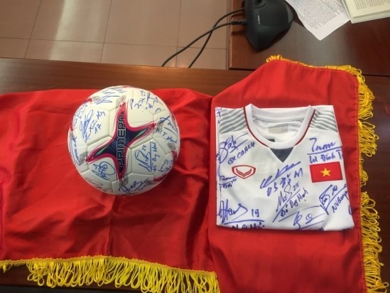 A football and a jersey bearing the signatures of all players and members of the coaching board of the male Vietnam national team who won the AFF Suzuki Cup 2018 will be auctioned to raise fund for the poor and AO victims (Source: http://baonhandao.vn)