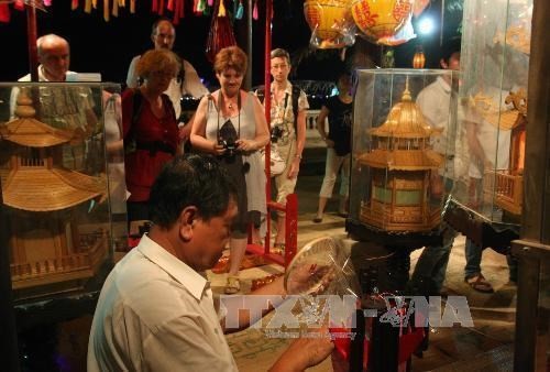 Foreign tourists visit a booth at the previous edition of the craft festival (Photo: VNA)