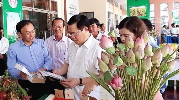Deputy PM Vuong Dinh Hue sees produce  at the meeting (Photo: SGGP) 