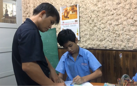 Phan Minh Thong is patiently teaching his students in the Binh Thanh School of Hope for Hearing-impaired People