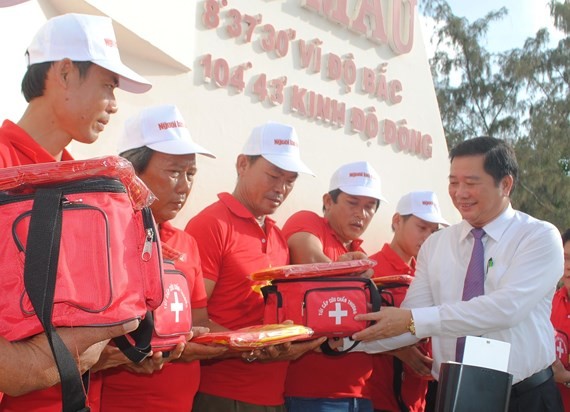 Deputy Chairman of Ca Mau People’s Committee Than Duc Huong gives flags to fishermen (Photo: SGGP)