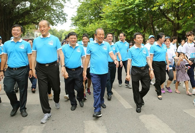 Deputy Prime Minister Truong Hoa Binh (front, fourth, left) and other people join a walk in Hanoi on June 23 (Photo: VNA)