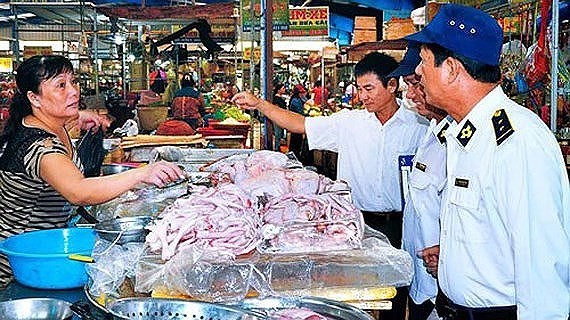 Inspectors visit a food booth in a tradiational market (Photo: SGGP)