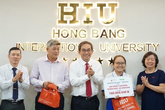 HIU President Ho Thanh Phong grants scholarship to the poor girl (Photo;l SGGP)