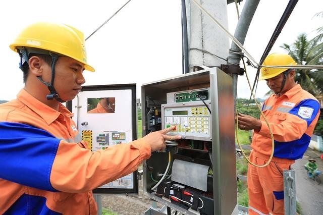Workers of Quang Ninh Electricity Company under the Northern Power Corporation install data transmission equipment. — VNA/VNS Photo