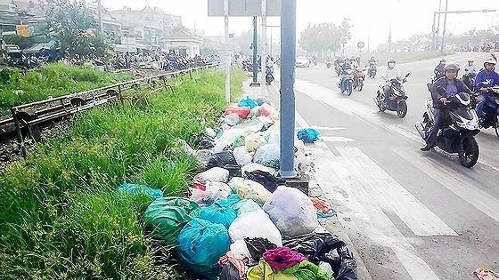 People throw away garbage in Pham Van Dong Street (PHoto: SGGP)