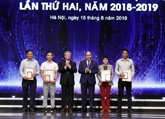 Prime Minister Nguyen Xuan Phuc (third from right) and the winners of press awards for the fight against corruption and wastefullness."(Photo: VNA)
