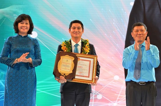 Deputy Editor-in Chief of Sai Gon Giai Phong Newspaper Ly Viet Trung gives prizes to a winner at the ceremony. (Photo: SGGP)