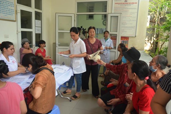 People wait for their turn for free examination (Photo: SGGP)