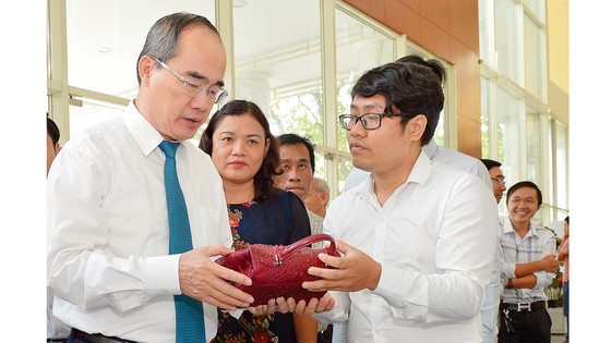 Party Chief Nguyen Thien Nhan sees handicraft products of agricultural cooperative at the conference (Photo: SGGP)