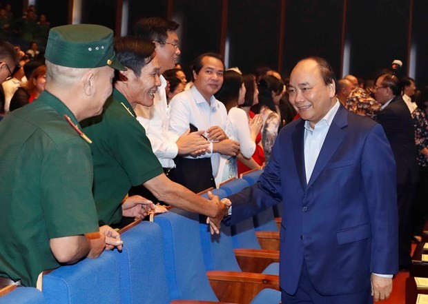 Prime Minister Nguyen Xuan Phuc (R) greets participants in the programme in Hanoi on October 17 (Photo: VNA)