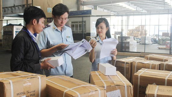 Customs officials check imported items (Photo: SGGP)