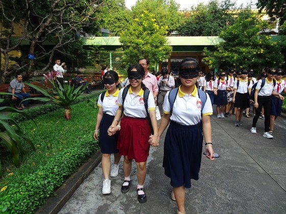 Students are blindfolded to understand their blind peers' difficulties  ( Photo: SGGP)
