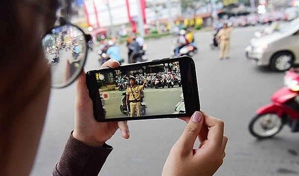 A citizen films a on-duty traffic police in HCM City. — Photo luatvietnam.vn