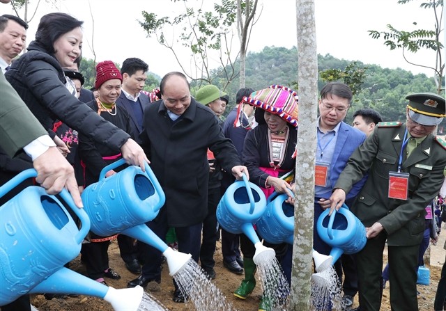 Prime Minister Nguyen Xuan Phuc (second from left) waters a tree after growing it as part of a tree-planting campaign launched in northern Yen Bai Province on Thursday (Photo: VNA)