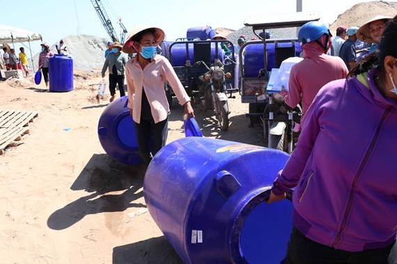 Poor residents in Ben Tre are happy to receive water containers (Photo: SGGP)