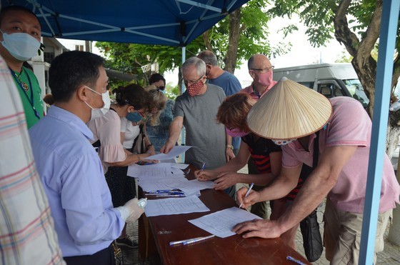 Foreigners are writing information at one of checkpoints in Da Nang (Photo: SGGP)