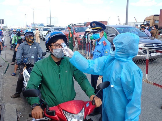 A driver has his body temperature taken before entering Ho Chi Minh City (Photo: SGGP)