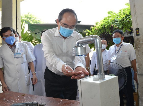 Secretary of the Ho Chi Minh City Party Committee Nguyen Thien Nhan washes his hand at automatic hand sanitizer dispenser at Thong Nhat Hospital (Photo: SGGP)