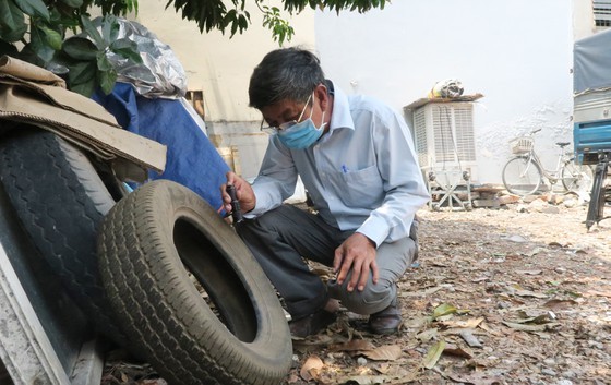 A medical worker is checking tyre dump site, a dengue hazard (Photo: SGGP)