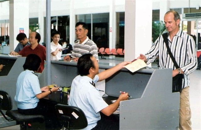 A customs official conducts immigration procedures for a foreigner at Tan Son Nhat airport in HCM City. — VNA/VNS Photo