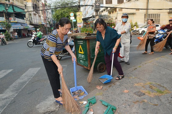 People clean streets in response to city authorities' campaign (Photo: SGGP)