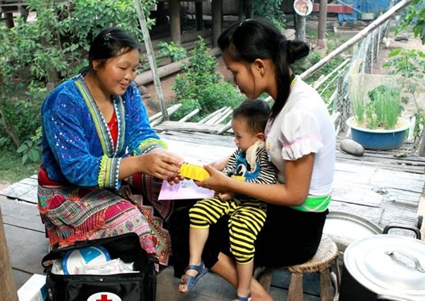 A village-based midwife gives health care guidance to a mother in Muong Nhe district, the northern mountainous province of Dien Bien. (Photo: VNA)