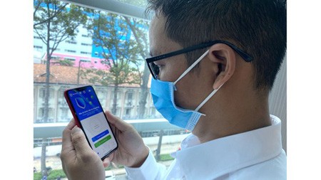 Wearing face mask and using Bluezone are two effective methods to prevent the spread of Covid-19 pandemic in the community at the moment. (Photo: SGGP)