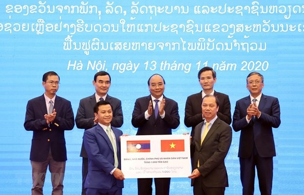 Deputy Minister of Foreign Affairs Nguyen Quoc Dung (R) hands over the token of the relief aid of 1,000 tonnes of rice from the Vietnamese Government to Lao Deputy Ambassador to Vietnam Chanthaphone Khammanichanh (Photo: VNA)
