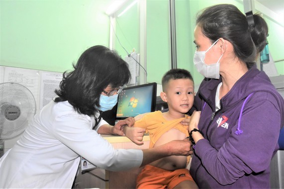 A physician is examining a child in Tan Binh District's medical center (Photo: SGGP)