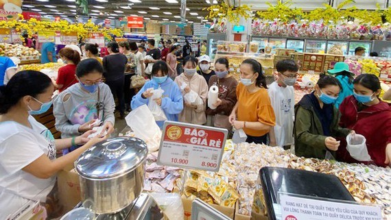 People buy things in a supermarket (Photo: SGGP)