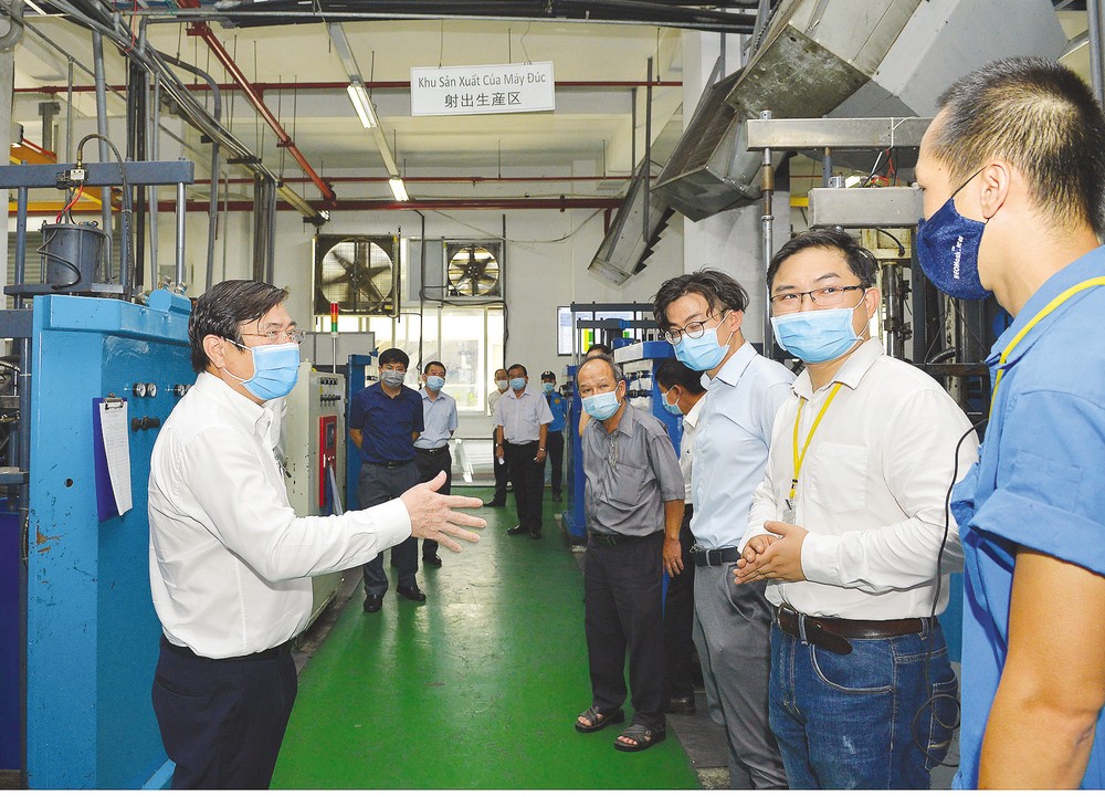Chairman of Ho Chi Minh City People's Committee Nguyen Thanh Phong directs workers in Tan Thuan Export Processing Zone how to prevent Covid-19 in April, 2020 (Photo: SGGP)