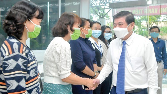 Chairman of the Ho Chi Minh City People’s Committee Nguyen Thanh Phong congratulates health workers of the city Center for Disease Control (Photo: SGGP)