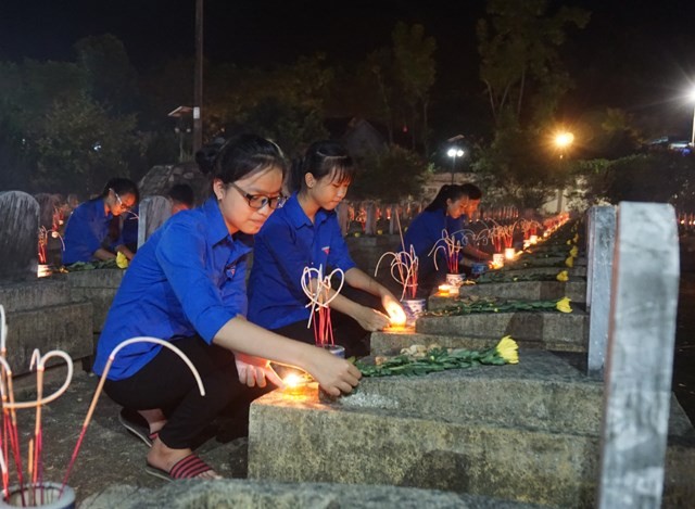 Students light up candles at the Vietnam-Laos martyr cemetery in the central province of Nghe An to remember more than 11,000 Vietnamese volunteer soldiers who laid down their lives in Laos during wartime. (Photo: dantri.vn)