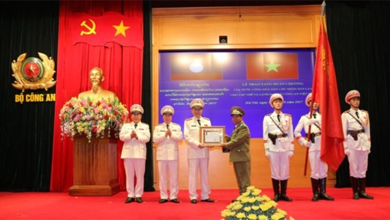 Lieutenant General, Minister of Security of Laos Somkeo Silavong  offers the first-class Development Medal of Lao People Democratic Republic to Ministry of Public Security of Vietnam