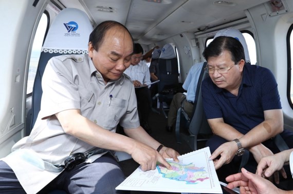 Prime Minister Nguyen Xuan Phuc (L)  inspects climate change impact in Mekong Delta region by helicopter