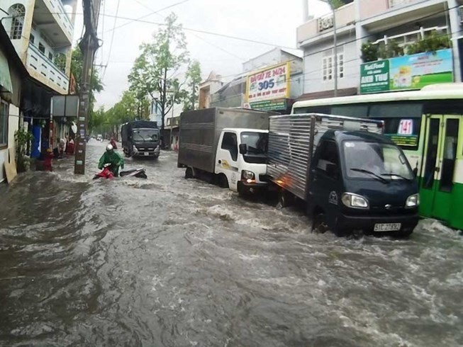 Drivers struggle to deal with flooding caused by heavy rains in HCM City. (Photo: VNA)