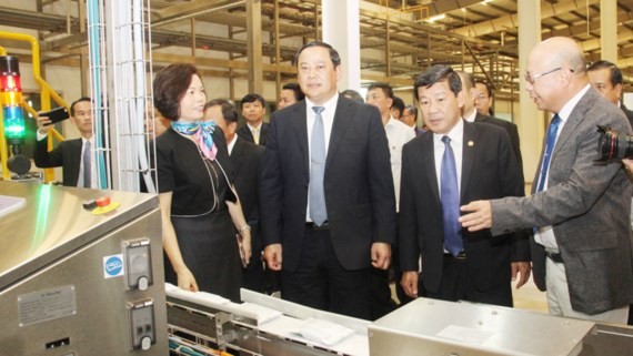 Lao Deputy Prime Minister Sonexay Siphandone visits a factory of Vietnam Dairy Products Joint - Stock Company