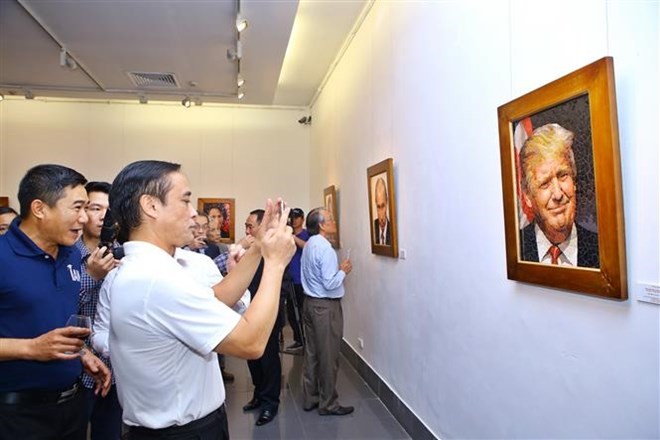 Visitors take a photo of a mosaic ceramic painting of US President Donald Trump (Photo: VNA)