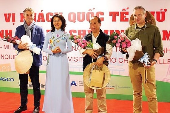 Deputy Chairwoman of  Ho Chi Minh City People’s Committee Nguyen Thi Thu offers flowers to the five millionth international visitor to Ho Chi Minh City at the welcoming ceremony 