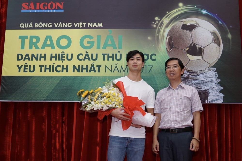 Deputy Editor in chief Nguyen Thanh Loi gives the cup to striker Nguyen Cong Phuong Photo: Hoang Hung