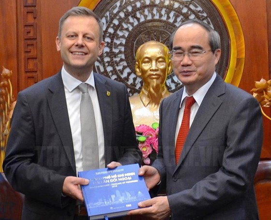 Secretary of the Ho Chi Minh City Party Committee Nguyen Thien Nhan offers a souvenir to Torsten Bonew 