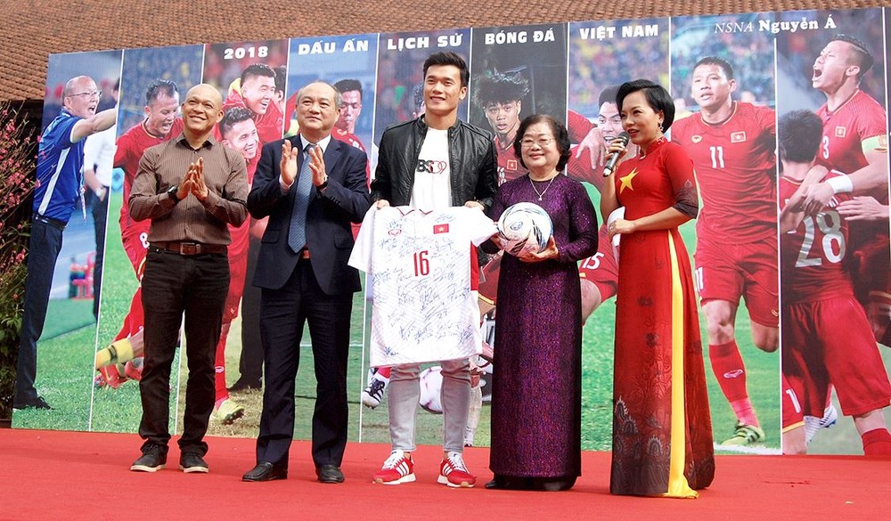 Former Vice President of Vietnam and Chairman of Vu A Dinh Scholarship Fund Truong My Hoa receives the jerseys and ball from representatives of the football team(Photo:Huy Dung)