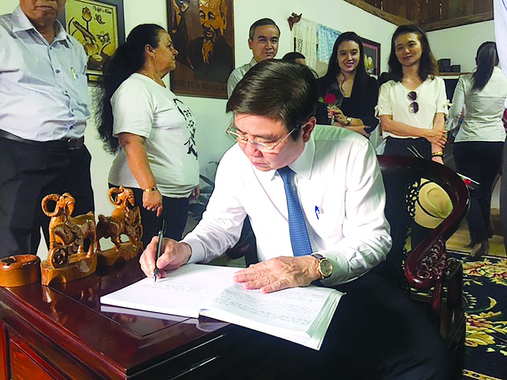 Chairman of the Ho Chi Minh City People’s Committee Nguyen Thanh Phong writes down a memory book at Vietnamese House in Cuba’s Ben Tre village.