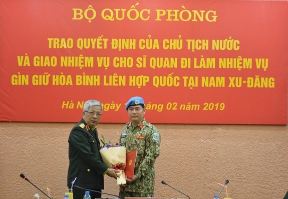 Deputy Minister of National Defence Sen. Lieut. Gen. Nguyen Chi Vinh (left) hands over the President’s decision to Lieut. Colonel Nguyen Kim Tinh. (Source: qdnd.vn)