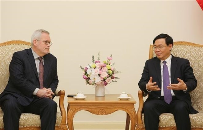Deputy Prime Minister Vuong Dinh Hue (R) receives Charles Freeman, Senior Vice President for Asia at the US Chamber of Commerce, in Hanoi on March 8 (Photo: VNA)
